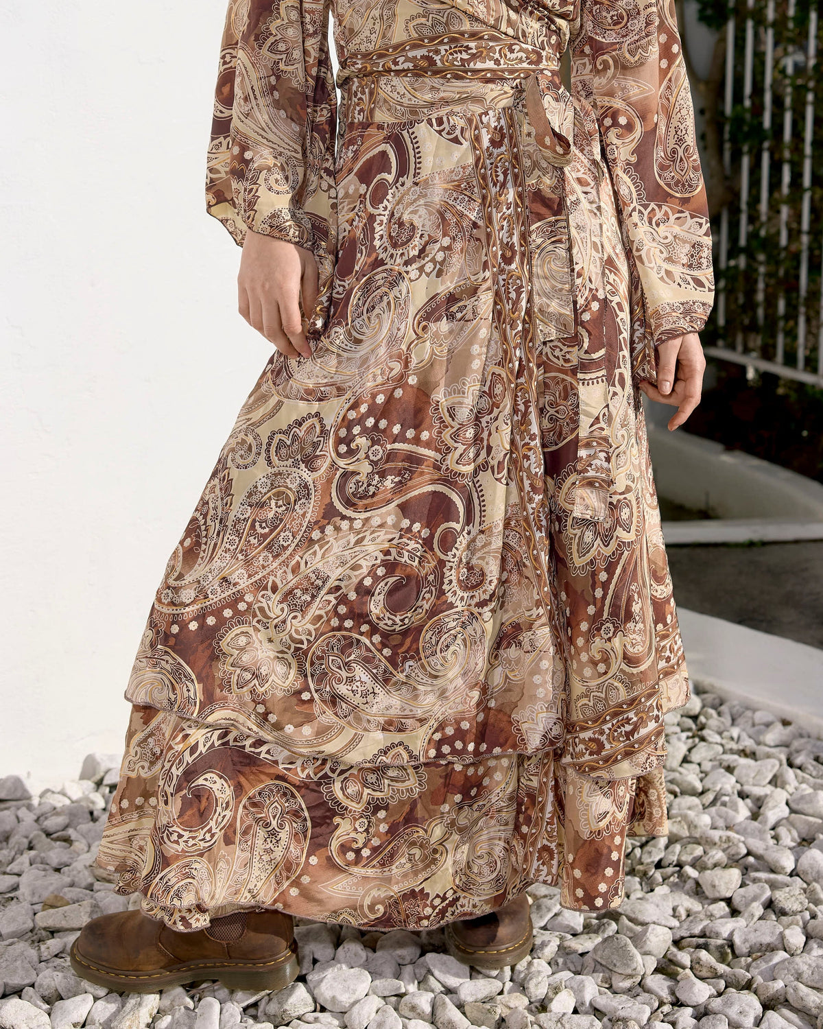 Model wearing the Wild Fawn Solea wrap maxi skirt in chocolate and cream paisley print with flowing kimono sleeves and waist tie.